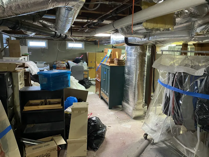 Basement cluttered with stored items and boxes