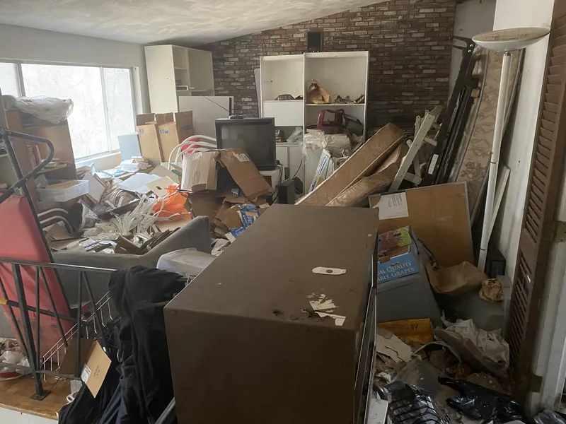 Room with fireplace filled with junk and old furniture
