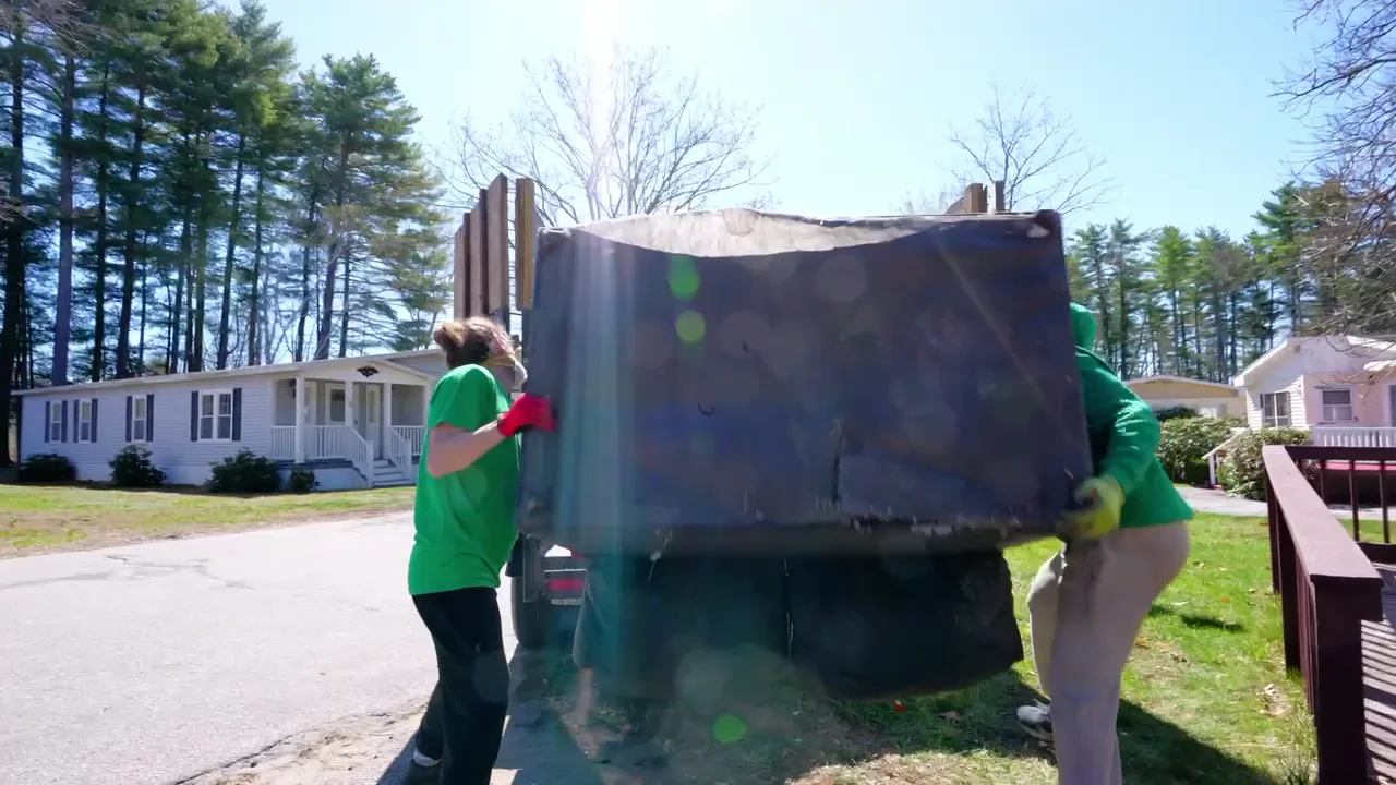 Trash King crew loading a full dump trailer during a residential cleanout